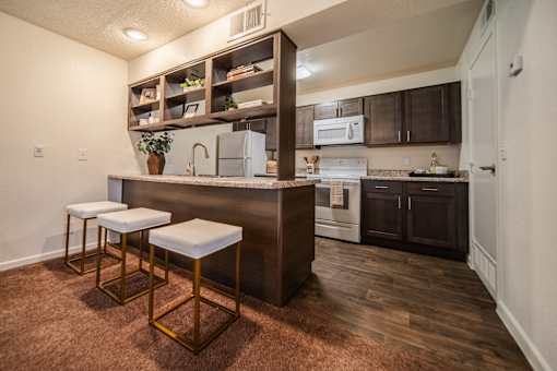 A kitchen with a bar stool and a counter.