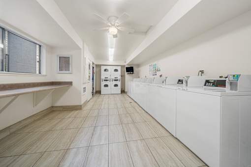 A laundry room with a counter and a fan on the ceiling.