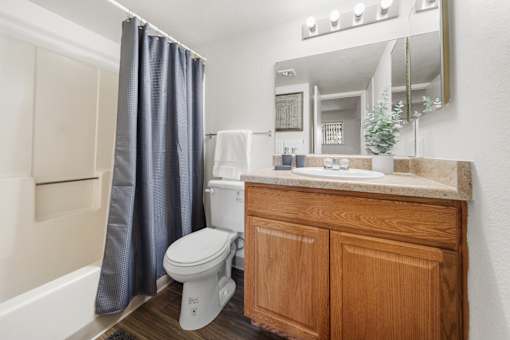 A white toilet sits in a bathroom next to a wooden cabinet.