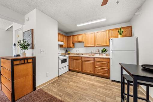 A kitchen with wooden cabinets and a white refrigerator.
