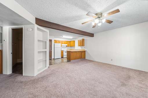 A room with a ceiling fan and a carpeted floor.