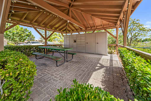 A covered patio with a table and chairs.
