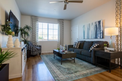 a living room with hardwood flooring and a ceiling fan