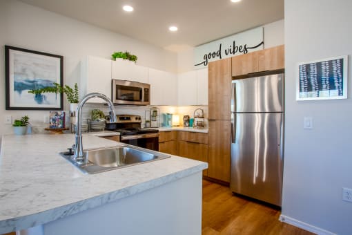 a kitchen with stainless steel appliances and a marble counter top