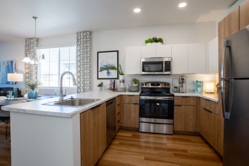 a kitchen with white cabinets and a large white island with a stainless steel sink and oven