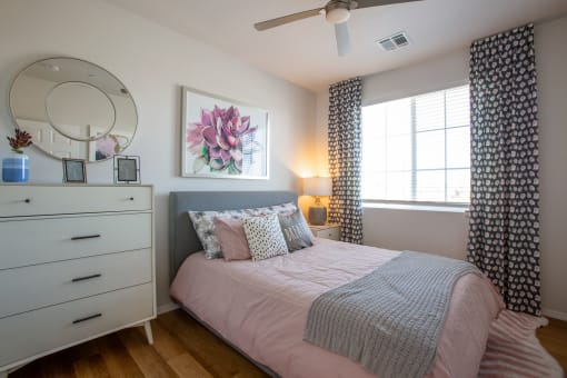 a bedroom with a bed and a dresser with a mirror on top of it