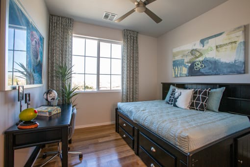 a bedroom with a large window and a desk with a plant