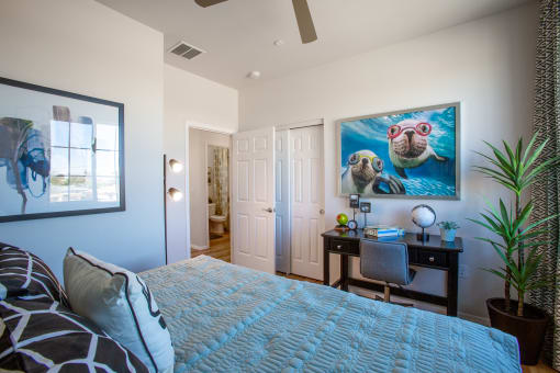 a bedroom with a large bed and a desk with a chair