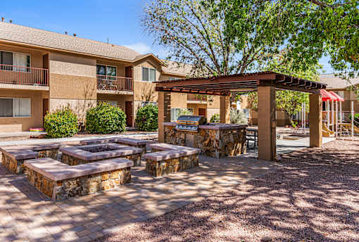 A firepit, BBQ and pergola at Courtside Apartments.