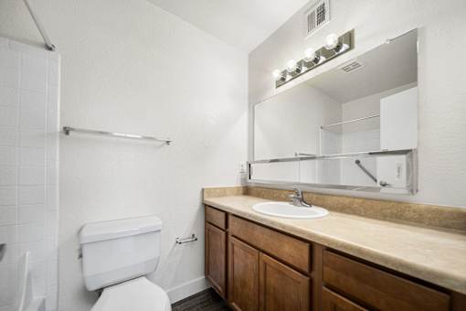 A white toilet sits next to a sink in a bathroom.
