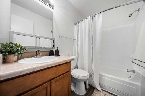 A bathroom with a white sink, toilet, and bathtub.