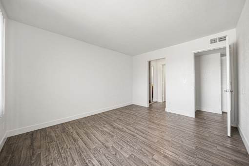 A room with wooden flooring and white walls.