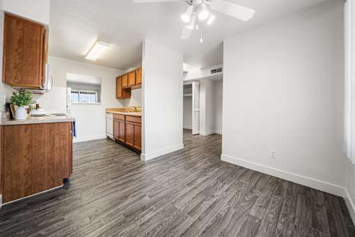 A kitchen with wooden cabinets and a grey floor.