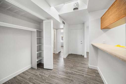 A long hallway with a white door and a white wall.