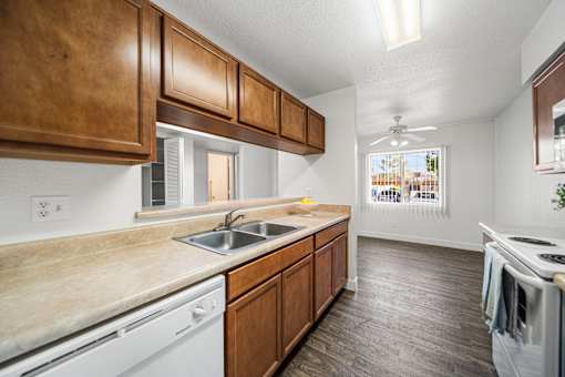 A kitchen with wooden cabinets and a white dishwasher.