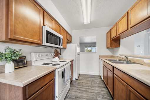A kitchen with wooden cabinets and a white stove top oven.