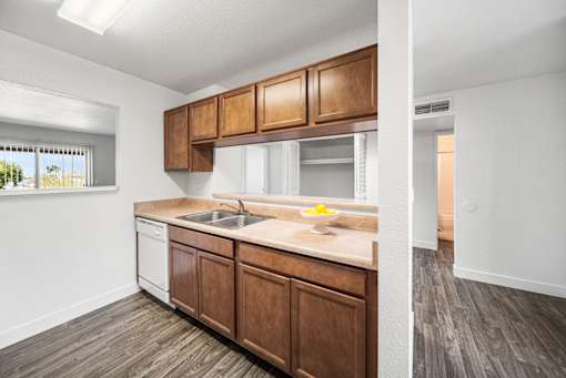 A kitchen with wooden cabinets and a white sink.