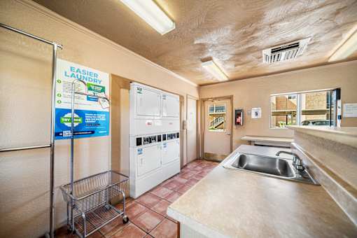 A laundry room with a sign that says "Easier Laundry" and a washer and dryer.