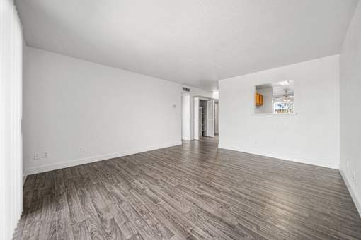 A room with wooden flooring and white walls.