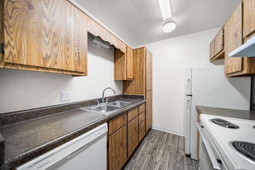 A kitchen with wooden cabinets and a white refrigerator.