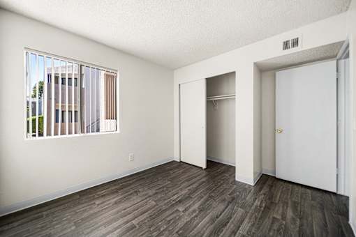 A bedroom with a window and a door.