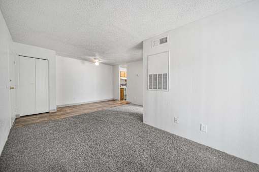A room with white walls and a grey carpet.