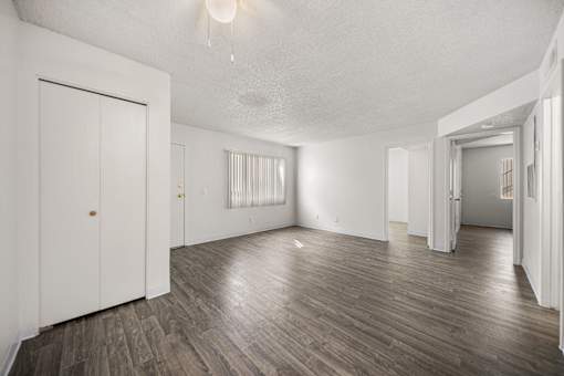 A room with vinyl floors and white walls.