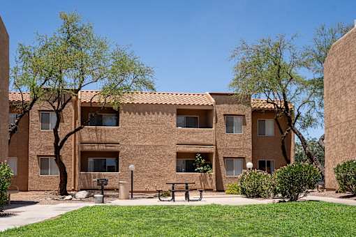 A building with a brown facade and a green lawn in front.