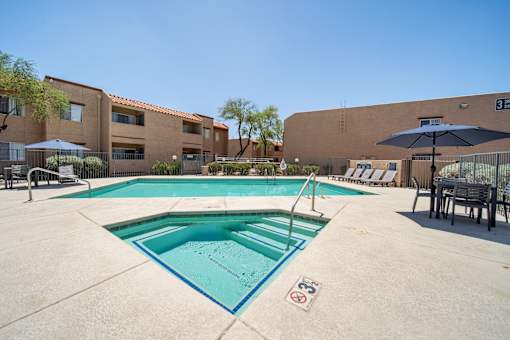 A swimming pool surrounded by a fence and buildings.