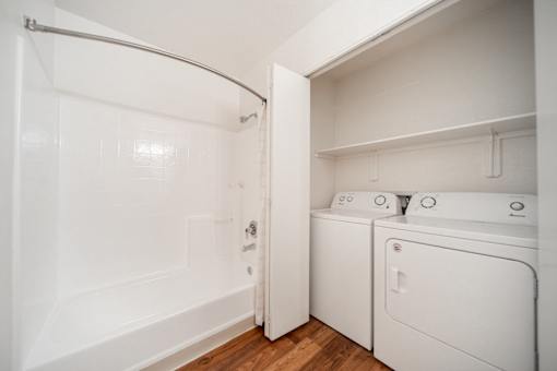 A white bathroom with a washer and dryer.