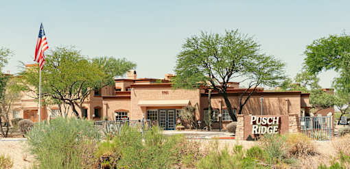 A building with a sign that says "Pusch Ridge" in front of it.