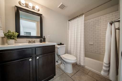 A bathroom with a toilet, sink, and shower.