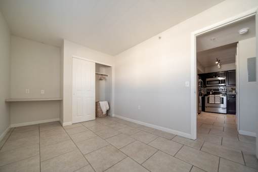 A kitchen area is visible through an open doorway.