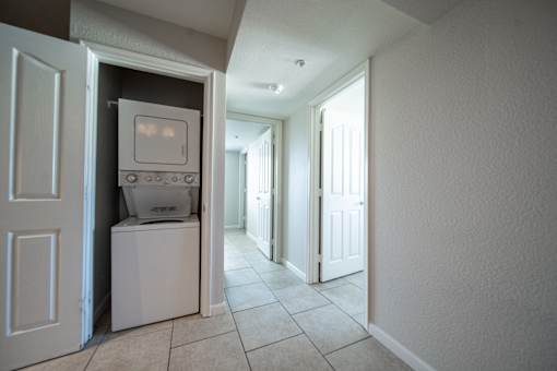 A white washing machine is in a small closet.