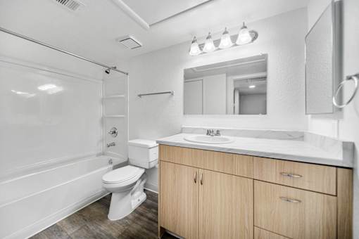 A white bathroom with a toilet, sink, and mirror.