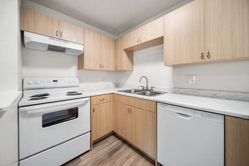 A kitchen with wooden cabinets and white appliances.
