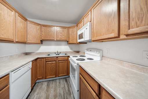 A kitchen with wooden cabinets and a white stove top oven.