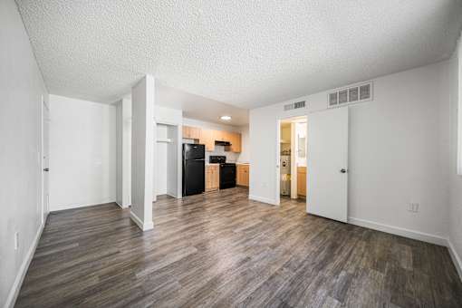 A room with a kitchenette and a dining area.