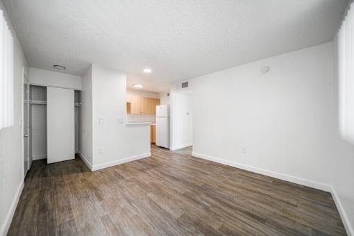 A room with wooden flooring and white walls.