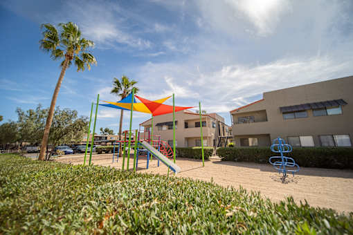 A playground with a slide and a climbing frame.