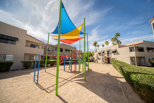 A playground with a colorful structure and a blue sky in the background.