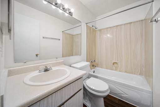 A white bathroom with a sink, toilet, and bathtub.