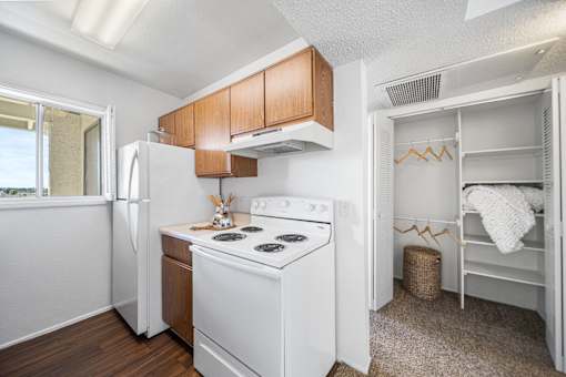 A small kitchen with white appliances and wooden cabinets.