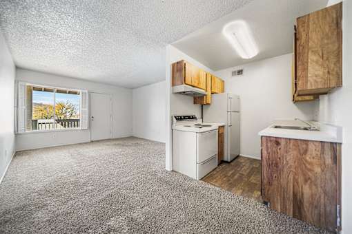 A kitchen area with a stove, refrigerator, and cabinets.