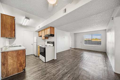 A kitchen with white appliances and wooden cabinets.