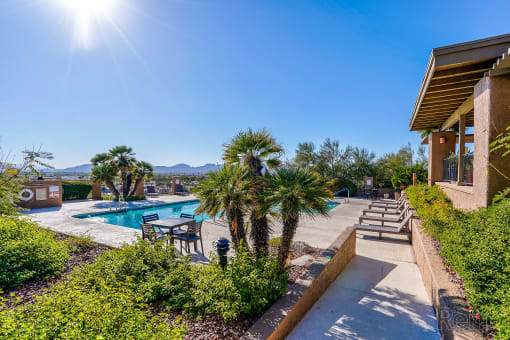 a swimming pool with palm trees in front of a house