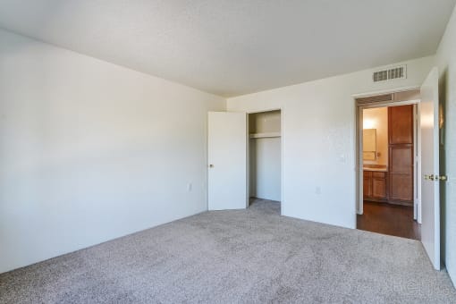 an empty living room with white walls and carpet