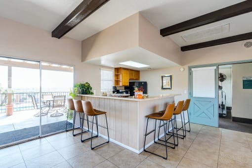 a kitchen with a bar and chairs in front of a door