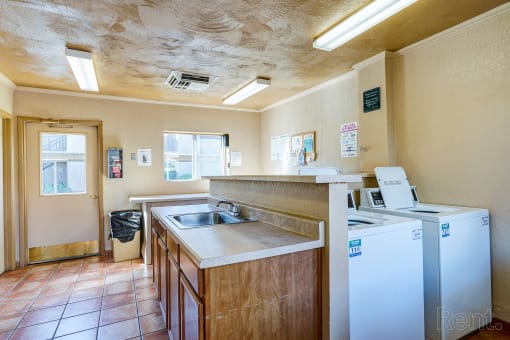a kitchen with a sink and a refrigerator and a washing machine