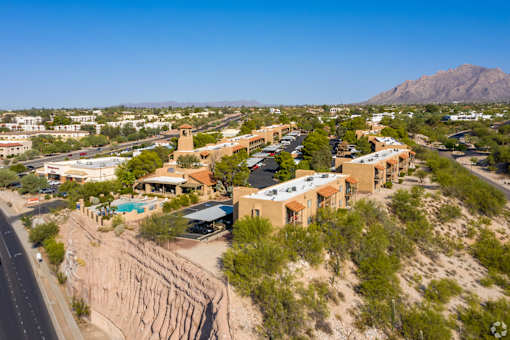 A desert landscape with a road and buildings.